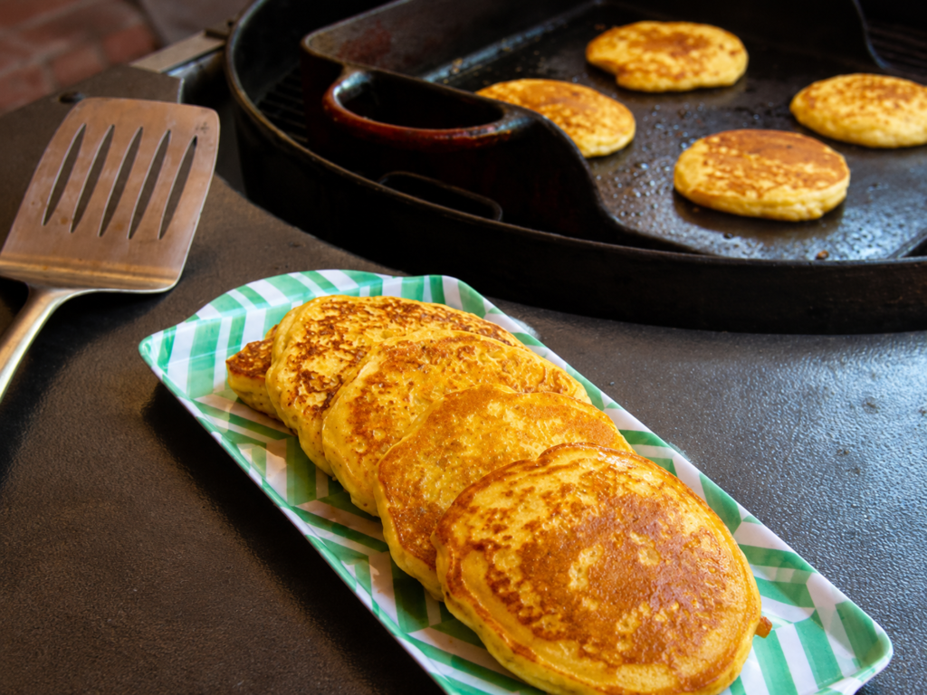 Corn cakes on a platter and on a griddle