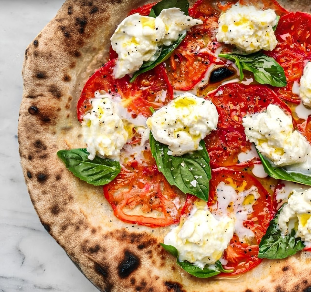 Pizza with tomatoes, basil, and burrata cheese
