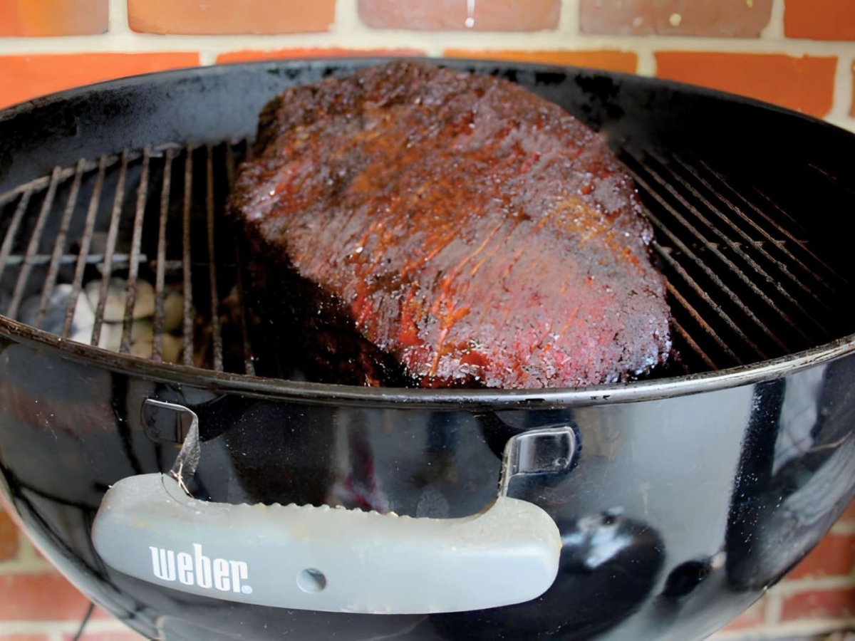Smoked brisket on a kettle BBQ grill.