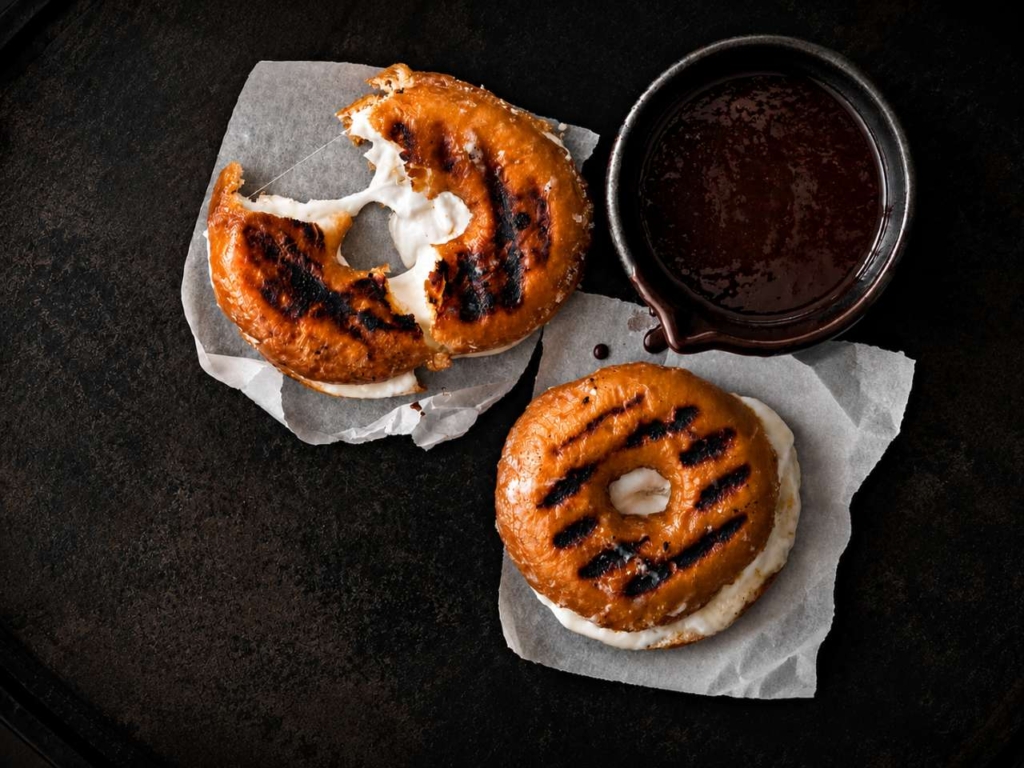 Grilled marshmallow filled donuts with chocolate sauce.