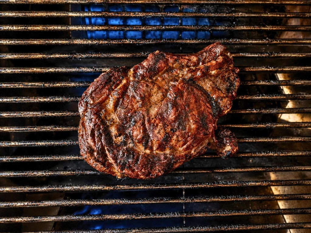 Steak on a grill grate.
