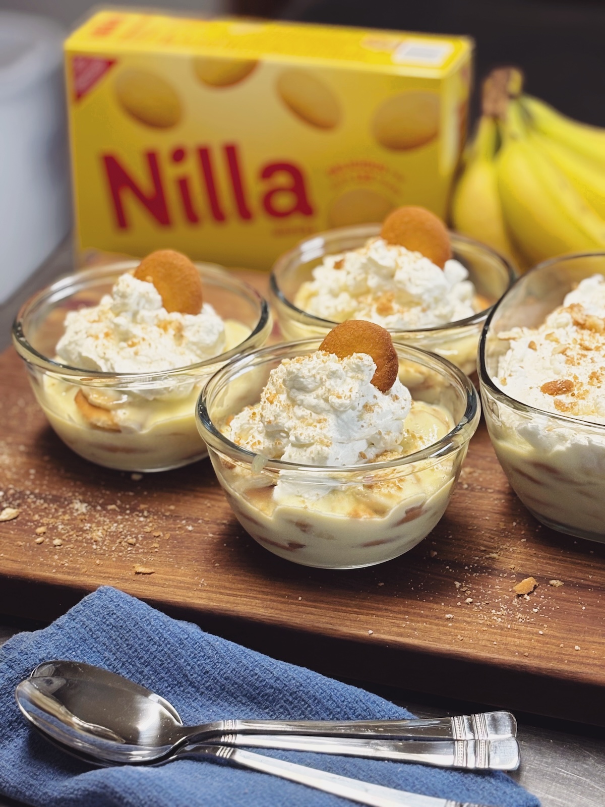 Banana pudding topped with whipped cream in glass bowls