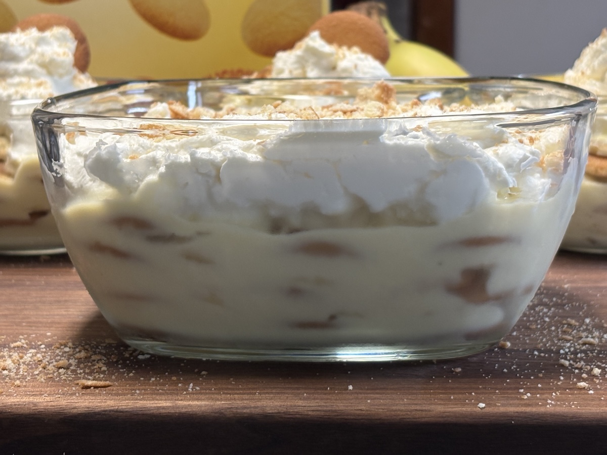banana pudding in glass bowl topped with whipped cream