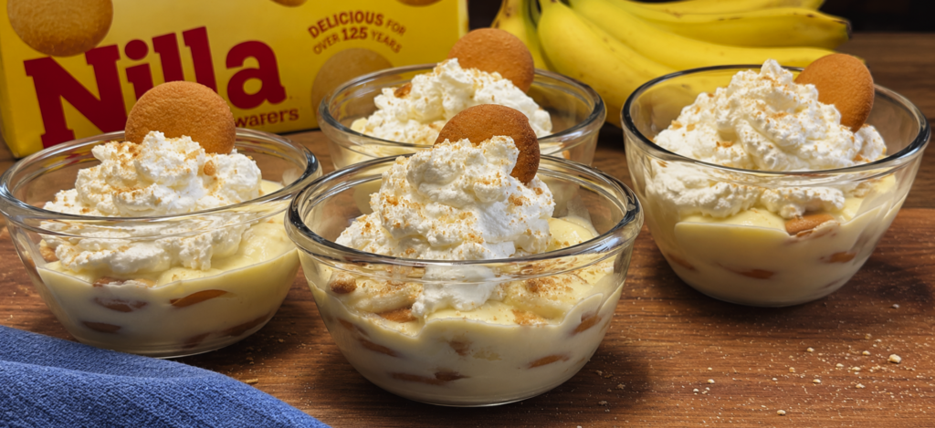 Banana pudding in glass bowls topped with whipped cream