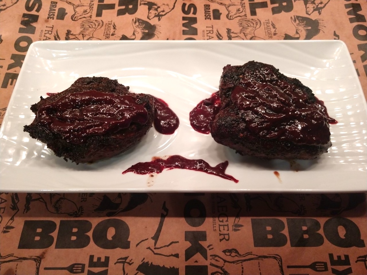 Blueberry BBQ Sauce recipe shown  spooned over meat on a rectangular white plate