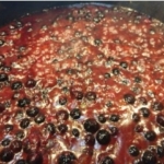 Blueberry BBQ sauce recipe in a pot showing the whole blueberries.