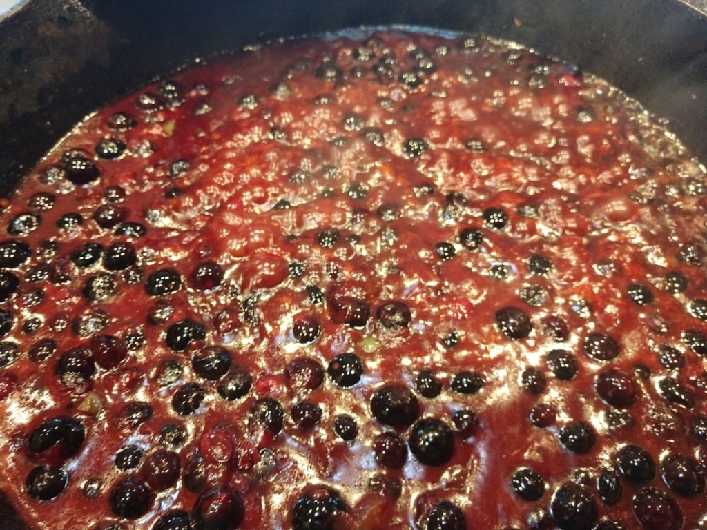 Blueberry BBQ sauce recipe simmering in pot showing whole blueberries.
