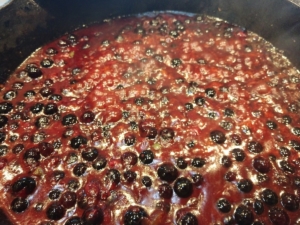 Blueberry BBQ sauce recipe simmering in pot showing whole blueberries.