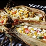 elote dip recipe in corn husks on a grill
