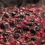Blueberry BBQ sauce recipe simmering in pot showing whole blueberries.