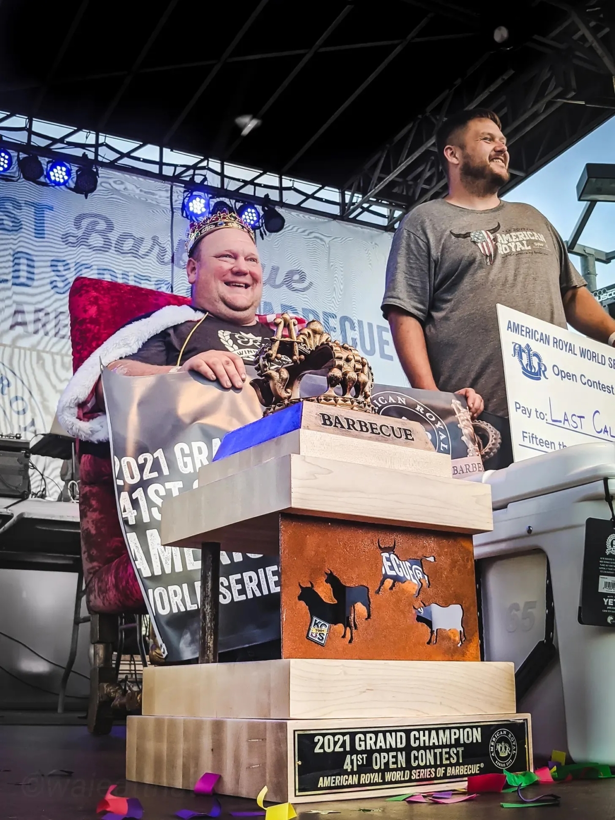 The Grand Champion of the American Royal World Series of Barbecue seated at the king's throne with a king's crown on his head.