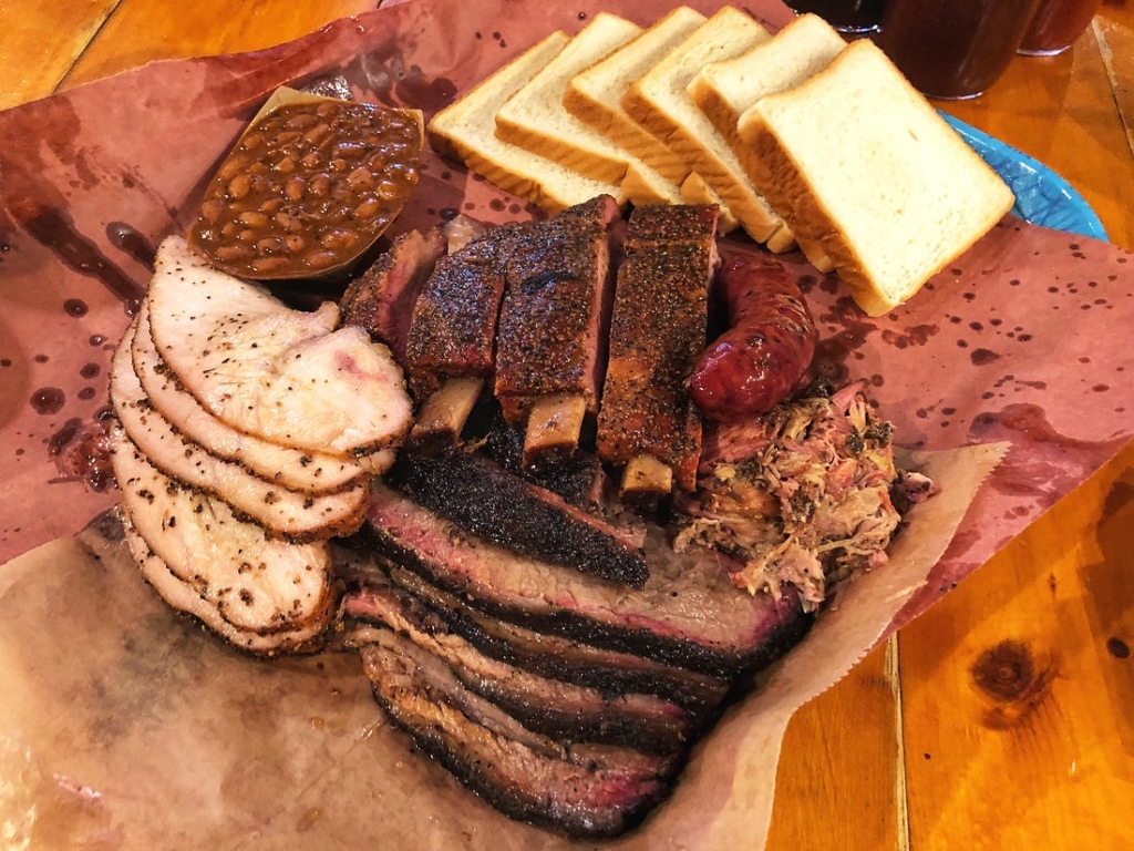 Platter of brisket, ribs, pulled pork, turkey, beans, and toast at Franklin Barbecue