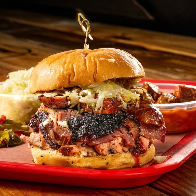 The Toddfather sandwich stacked with multiple meats at Cattleack BBQ in Dallas, Texas.