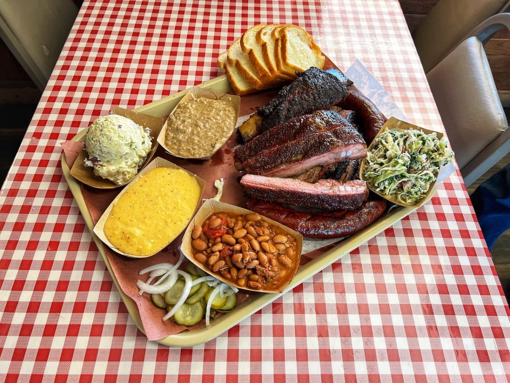 Platter of BBQ beef ribs, pork ribs, sausage, beans, and slaw at Goldee's Bar-B-Q in Fort Worth, Texas.