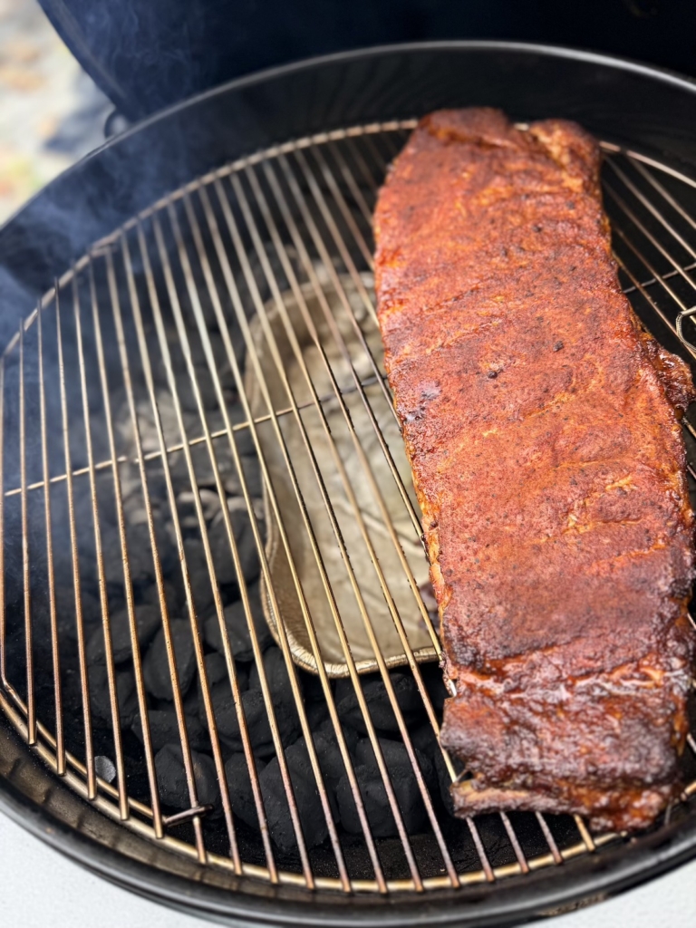 Rack of ribs on a Weber 22-inch Performer Smart Charcoal Grill.