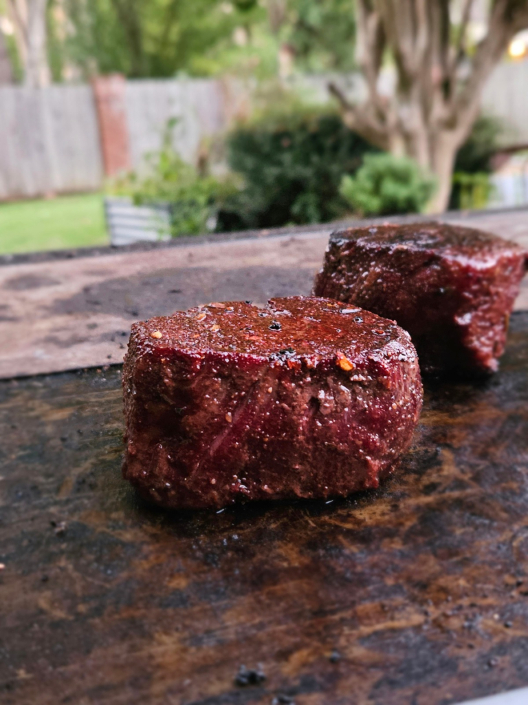 Two filet mignons on griddle plates.