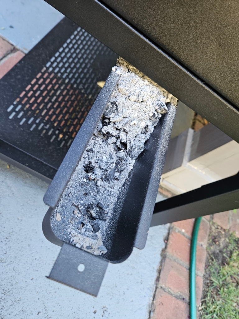 Removeable ash pan filled with ask.