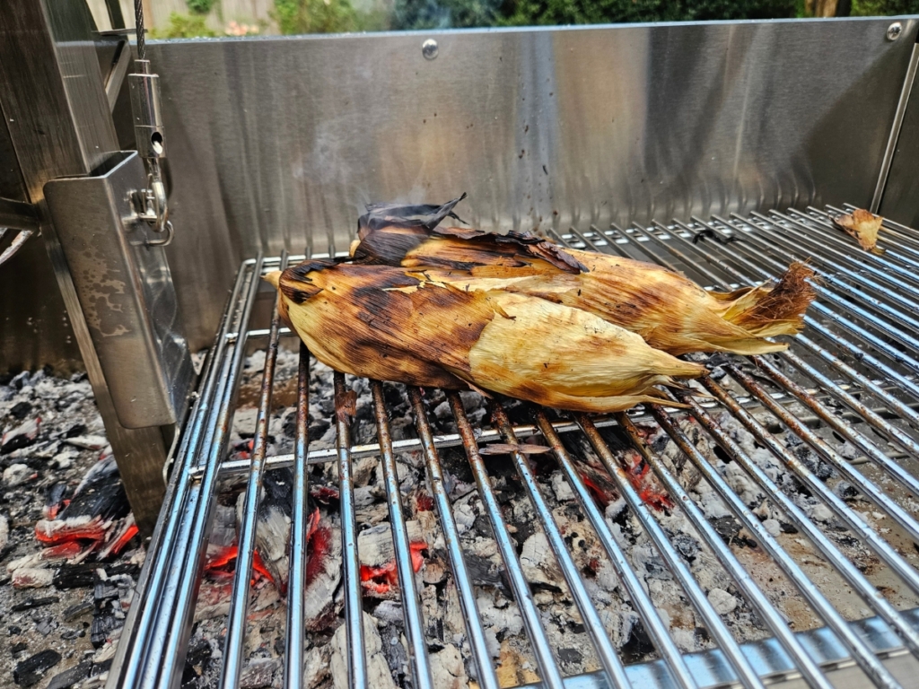 Charred corn on a grill.