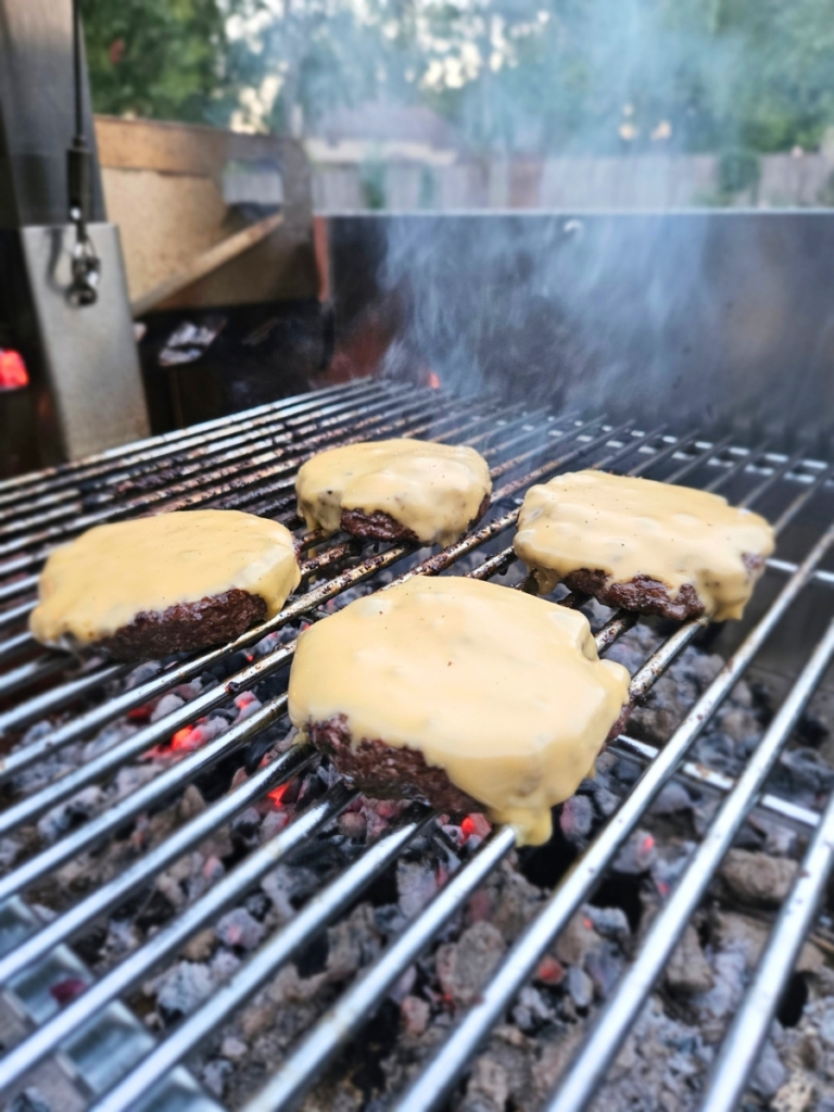 Cheeseburgers on a grill grate.