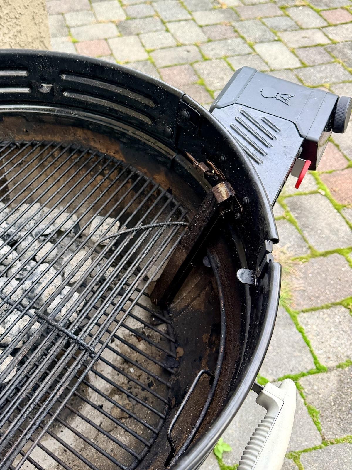Weber Kettle Smart Ring installed on a charcoal grill with the hinged grate in the lower grate height position.
